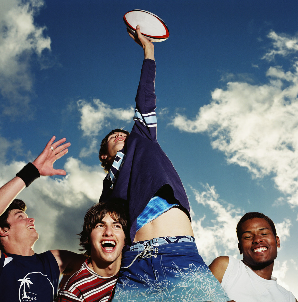 Group of Young Men Playing Football — Image by © Royalty-Free/Corbis